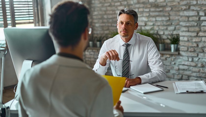 Businessman talking to a candidate during job interview in the o